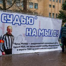 In this handout photo provided by Young Guards of United Russia party press service shows a group of demonstrators holding a banner with a photo of American Ice Hockey referee Brad Meier and message reading " Turn the referee into soap,” which is indeed a Russian expression, as awful as it seems, as they protest against a controversial disallowed goal  Meier, who overturned Russia’s third goal during the match between U.S. and Russia teams on Saturday near the U.S. Embassy in Moscow, Russia, Monday, Feb. 17, 2014. The demonstration was organized by the Young Guard, the youth wing of the Kremlin political party United Russia. (AP Photo/Voroshirin Dmitriy, Young Guards)