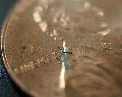 The micro-windmill, shown here on the surface of a penny, developed by University of Texas Arlington researchers. (Credit UT Arlington)