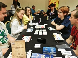 Photo of people playing the chemistry-based board game Compounded.